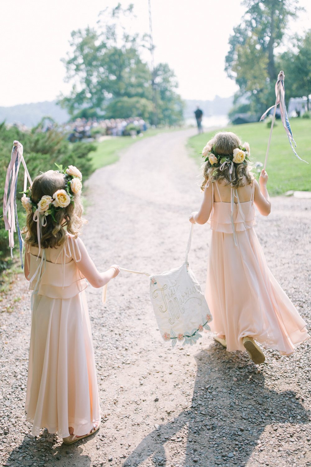flower girls with here comes the bride sign