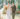 bride and groom smile as they walk down the aisle while guests throw rice
